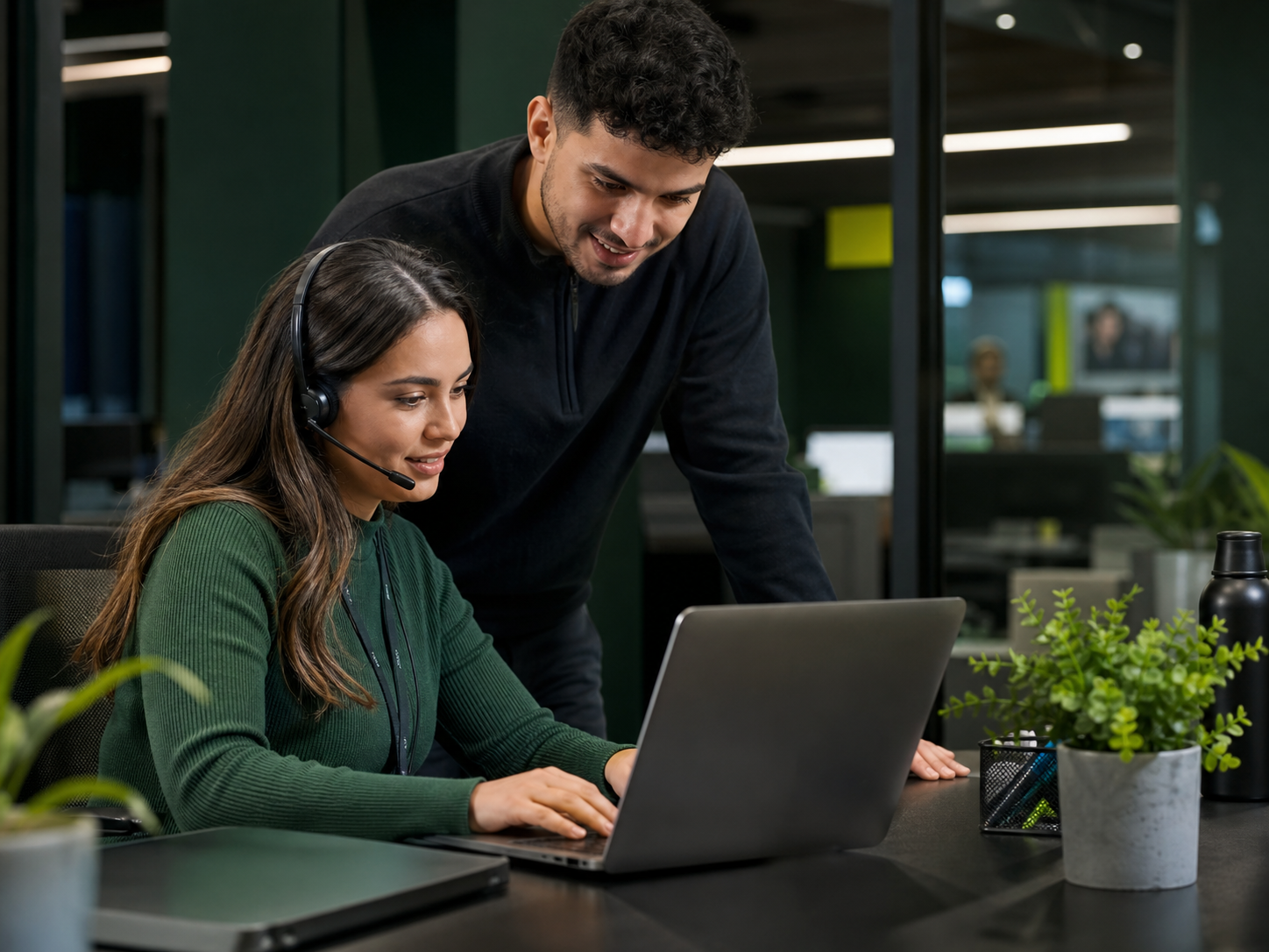 Two customer-support colleagues collaborating during a call-center shift